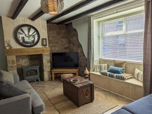 a living room with a fireplace and a tv at Harbour Way Cottage by Coast & Country Stays in Seahouses