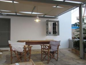 a patio with a wooden table and chairs at Cozy Beachfront Escape in Lilikas in Lilikás +14 photos