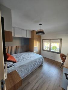 a bedroom with a bed and a window at Belle Maison avec Jardin in Pierrelaye
