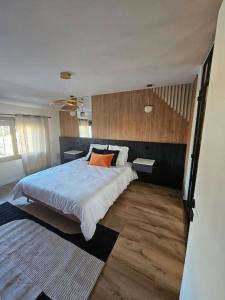 a bedroom with a large bed and wooden floors at Belle Maison avec Jardin in Pierrelaye