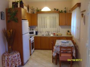 a kitchen with a table and a white refrigerator at Elisabeth Villas in Kerveli