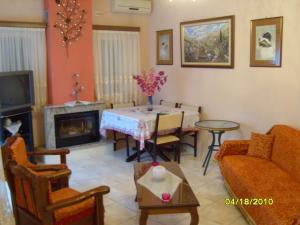 a living room with a table and a fireplace at Elisabeth Villas in Kerveli