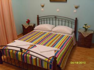 a bedroom with a large bed with colorful sheets and pillows at Elisabeth Villas in Kerveli