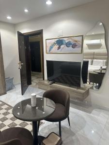 a living room with a fireplace and a table at Duba gold in Ḑubā