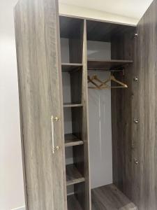 a closet with a wooden door and shelves at Duba gold in Ḑubā
