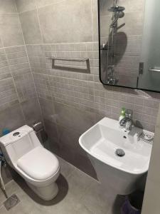 a bathroom with a white toilet and a sink at Duba gold in Ḑubā
