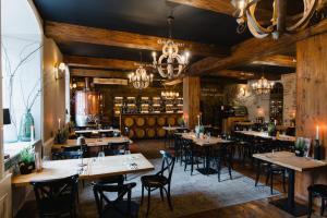 a restaurant with wooden walls and tables and chairs at Hotel Podklasztorze in Sulejów