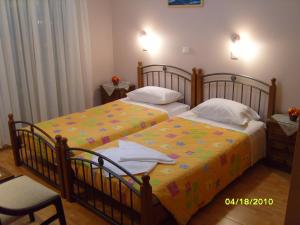 two beds in a hotel room withskirts at Elisabeth Villas in Kerveli