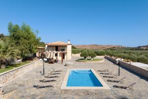 a resort with a swimming pool and chairs and a building at Nestor Villa, with Heated Pool & Absolute Privacy in Roumelí