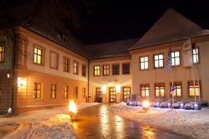 a building with lights in the snow at night at Klosterbräuhaus Ursberg in Ursberg