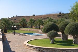 a park with trees and bushes and a hill at Nestor Villa, with Heated Pool & Absolute Privacy in Roumelí +27 photos