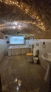 a bathroom with a tub and a toilet and a sink at Cueva romántica - Jacuzzi in La Cabrera