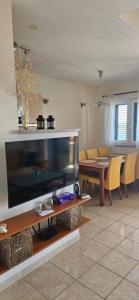 Una sala de estar con un televisor de pantalla plana grande. en Adriapartman, en Rogoznica