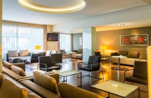 a hotel lobby with couches and chairs and tables at Port Feria Valencia in Valencia