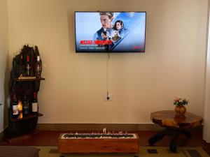 a living room with a television on the wall at Chalé Vista do Paraíso in Gonçalves