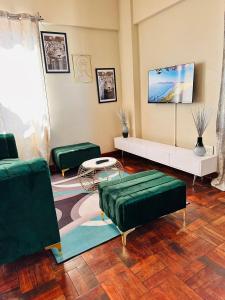 a living room with green couches and a table at Luxury Stay With Affordable Price in Johannesburg +16 photos