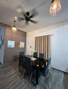 a dining room with a ceiling fan and a table and chairs at Village Rest House in Port Dickson