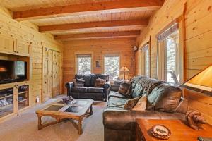 a living room with leather furniture in a log cabin at Cle Elum Mountain Cabin with Hot Tub and Hiking! in Cle Elum