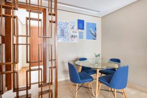 a dining room with a glass table and blue chairs at TT holidays Casa Oasis in Casablanca