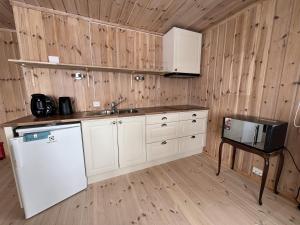 a kitchen with a white refrigerator and a sink at Koselig Gjestehus Med Badstue in Beitostøl