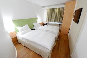 ein Schlafzimmer mit einem großen weißen Bett mit weißen Kissen in der Unterkunft Good Morning Kista in Stockholm