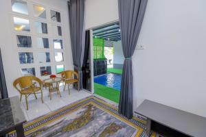 a living room with a table and chairs and a window at AL HAA SYA Homestay With Pool in Dungun