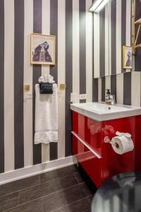 een badkamer met een rode wastafel en gestreepte muren bij Duplex 3 Bed 2 Bat Apt Steps from Lincoln Square in Chicago