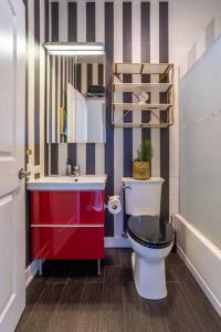 een badkamer met een rode wastafel en een toilet bij Duplex 3 Bed 2 Bat Apt Steps from Lincoln Square in Chicago +47 foto's