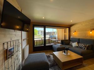 a living room with a couch and a table at Homency - Résidence La Meije 5 in L'Alpe-d'Huez