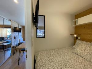 a bedroom with a bed and a dining room at Homency - Résidence La Meije 5 in L'Alpe-d'Huez