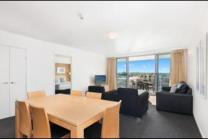 a dining room and living room with a table and chairs at Pool View Retreat in Ballina