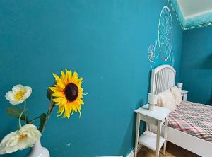 Un dormitorio con una pared azul con un girasol en la pared. en Timisoara Central Vibes Belle Vue Apartments, en Timisoara
