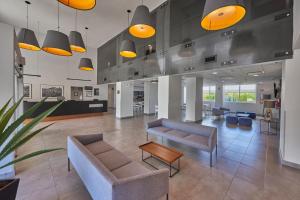 an office lobby with couches and chairs and lights at City Express by Marriott Tehuacan in Tehuacán
