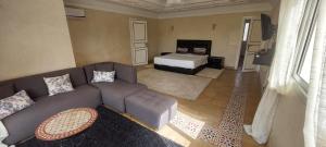 a living room with a couch and a bed at Villa Rayan Marrakech secteur Palmeraie dans Propriété de 2 hectares avec jardin arbres fruitiers in Marrakesh +62 photos