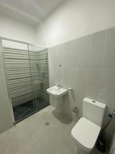 a bathroom with a toilet and a shower and a sink at Apartamento Rua do museu dos Náufragos in Sal Rei +13 photos
