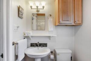 un bagno con lavandino, WC e specchio di Cozy cottage by the Sea -near downtown with patio! a Gulfport