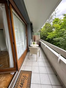 a porch with a table and a chair on a balcony at Studio 30m2 à 1O min du métro Pont de Sèvres L9 in Sèvres +2 photos