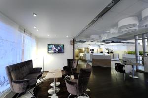 a waiting room with chairs and a table and a tv at Good Morning Kista in Stockholm