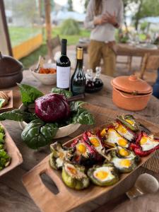 a wooden table with a plate of eggs and bottles of wine at Estancia Palma in Tupungato