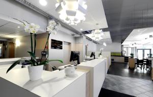 una oficina con mesas de recepción y plantas blancas en Good Morning Kista en Estocolmo