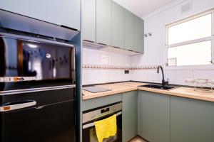 une cuisine avec des armoires blanches et un réfrigérateur noir dans l'établissement Jose Hurtado ID202, à Torrevieja