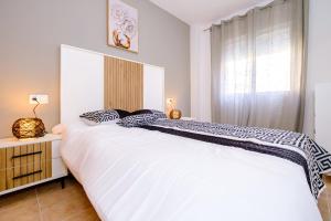 une chambre avec un grand lit blanc et une fenêtre dans l'établissement Jose Hurtado ID202, à Torrevieja