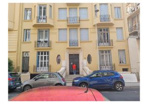 une personne debout devant un bâtiment dans l'établissement Extraordinaire grand studio au centre 6 minutes à pied de la plage et l'hôtel Negresco, à Nice