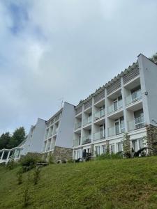 an apartment building with a grassy hill in front of it at Apartament Zielony Gaj Ustroń Wczasowa 90 in Ustroń