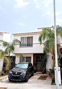 a black car parked in front of a house at La casa de Barbie Hermosa casa con alberca in Estrada