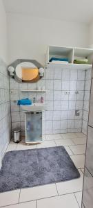 Una cocina con una alfombra sobre un suelo de baldosas blancas. en Ferienwohnung am Althanshof, en Bendorf