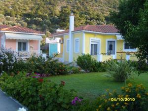 a yellow house with a yard with flowers at Elisabeth Villas in Kerveli