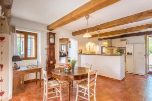 a kitchen and dining room with a wooden table and chairs at Villa La Bergerie by Villa Plus in Saint-Cézaire-sur-Siagne