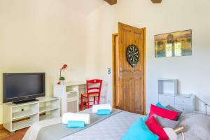 a small room with a bed and a television at Villa La Bergerie by Villa Plus in Saint-Cézaire-sur-Siagne