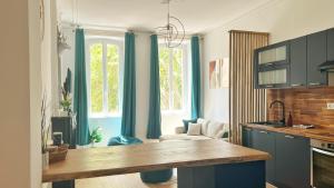 a kitchen with blue cabinets and a table in a room at Grand Cosy Family Stay - Centre historique Avignon in Avignon